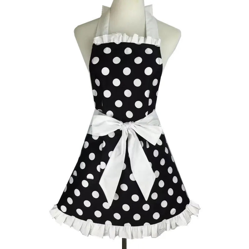A black polka dot ruffle apron with white trim and a bow displayed on a mannequin.