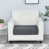 A white armchair with a dark gray seat cushion cover placed on a light-colored rug.