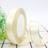 Roll of cream satin ribbon with a gold edge for gift wrapping and crafts