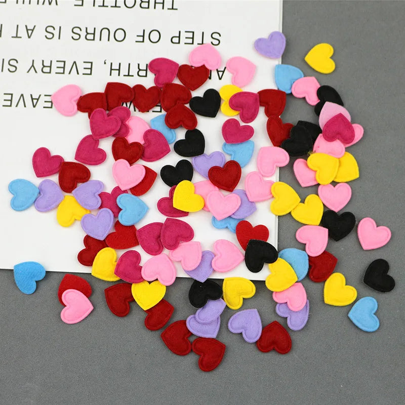 A colorful assortment of felt heart appliques in various shades of pink, red, yellow, purple, and blue scattered on a white s