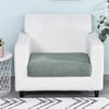 A white armchair with a green fleece seat cushion cover placed on a wooden floor.