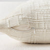 A cream-colored boucle texture throw pillow cover with a zippered opening.