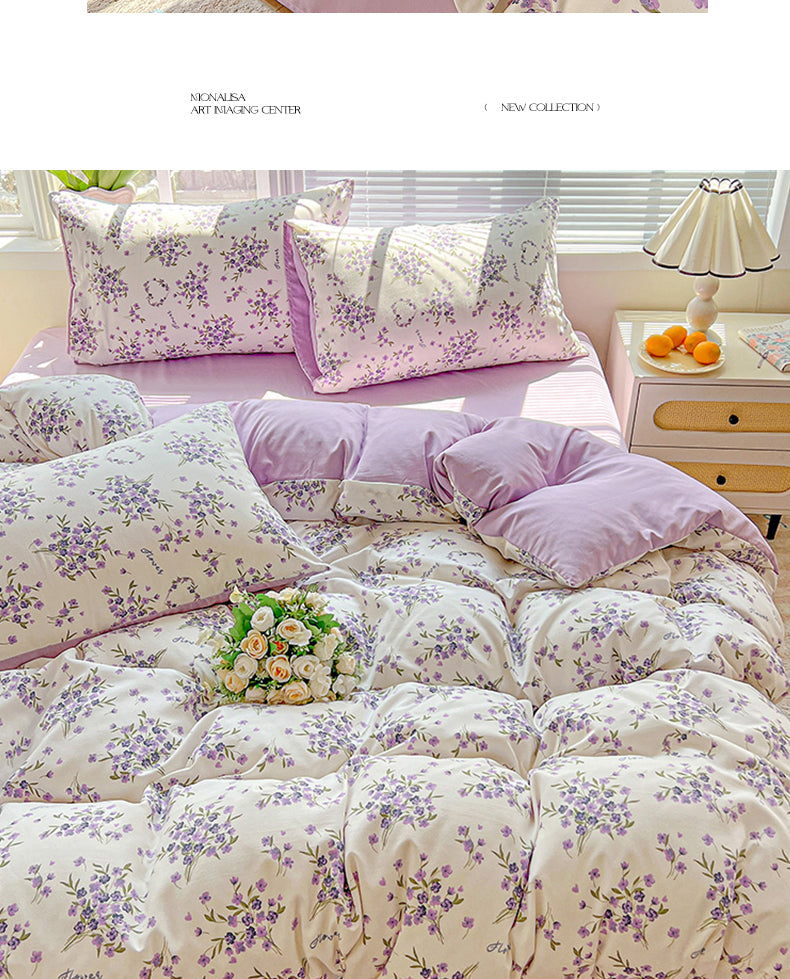 A floral printed bedding set featuring lavender and white flowers on a bed with sheer white blinds.