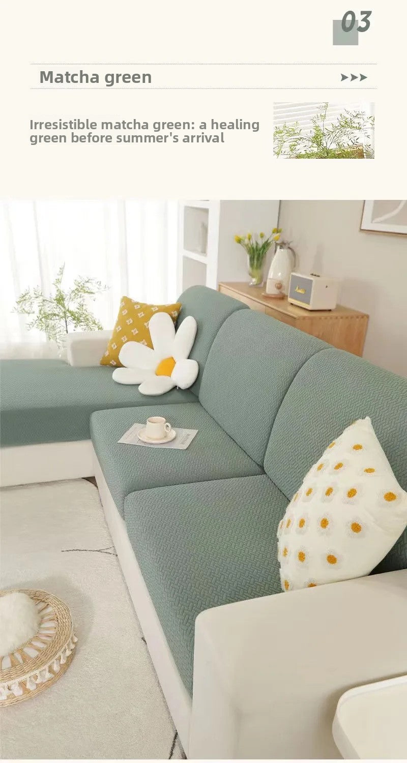 A light green sofa seat protector cushion cover with white floral accents in a bright living room setting.