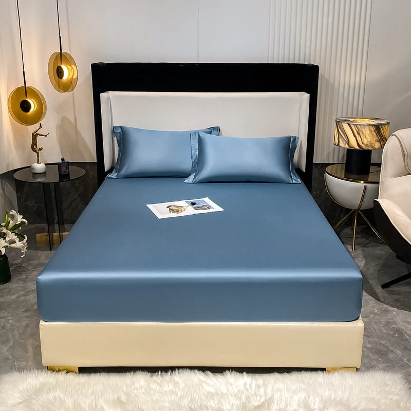 A luxury bed featuring a blue fitted sheet, pillows, and a dark headboard in a modern bedroom setting.