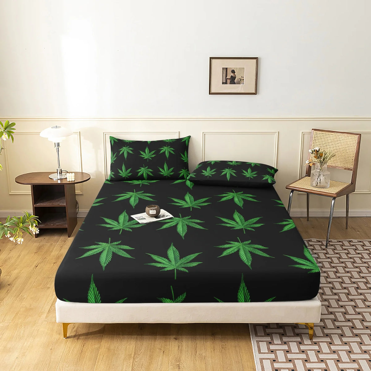 A black fitted sheet with a green hemp leaf print displayed on a bed.