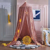 A pink princess hanging bed canopy with sparkling lights draped over a wooden bed frame.