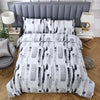 A white duvet cover with black and gray abstract brushstroke pattern displayed on a bed.
