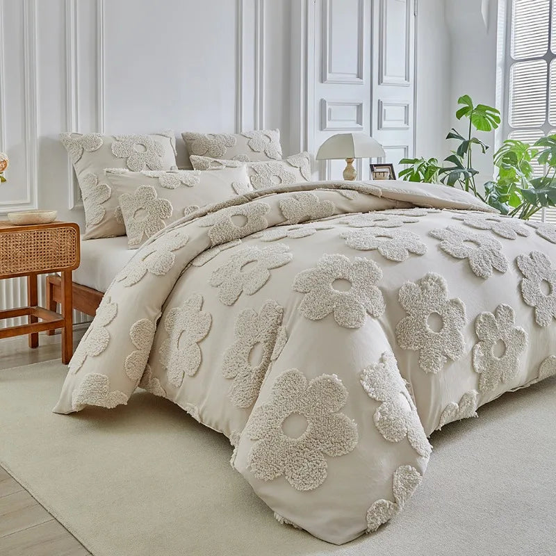 A beige tufted floral duvet cover set with matching pillowcases displayed on a bed in a bright room.
