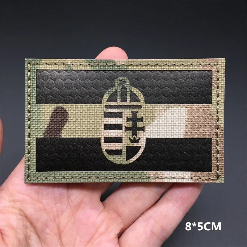A rectangular tactical flag patch featuring a black and olive green striped design on a dark background.