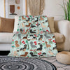 A light mint green flannel blanket featuring a pattern of various dog breeds in autumnal colors and festive accents.