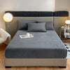 A gray luxury velvet bedding set featuring a fitted sheet and pillows on a bed with a dark upholstered headboard.