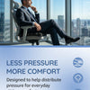 A man sits in an ergonomic chair with a seat cushion, demonstrating the comfort of a less pressure design.
