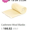 A rolled cashmere wool blanket in a pale yellow color displayed for sale.