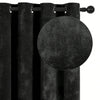 A close-up of a black velvet blackout curtain hanging on a rod.
