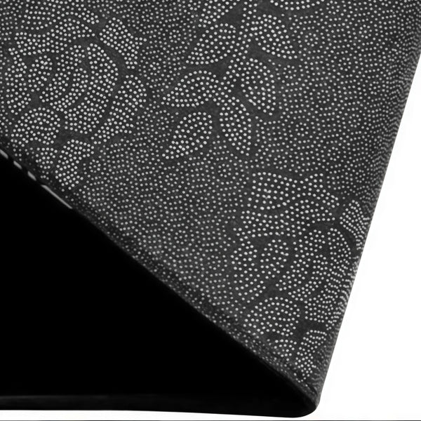Close-up of a black vintage stone doormat with a speckled pattern, shown at an angle.