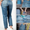A pair of dark blue denim jeans with close-up shots showing iron-on patches and fabric details.