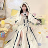 A woman wearing a white and black striped faux fur kimono robe indoors.