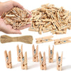 A collection of mini wooden clothespins with jute twine, some held in a hand and others laid out for crafts.