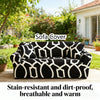 Black and white stain-resistant sofa cover displayed outdoors in a garden setting.