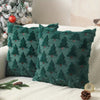 Two dark green textured plush throw pillows shaped like Christmas trees on a white surface.