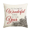 A cream-colored pillow featuring red script text that reads It's the most wonderful time of the year