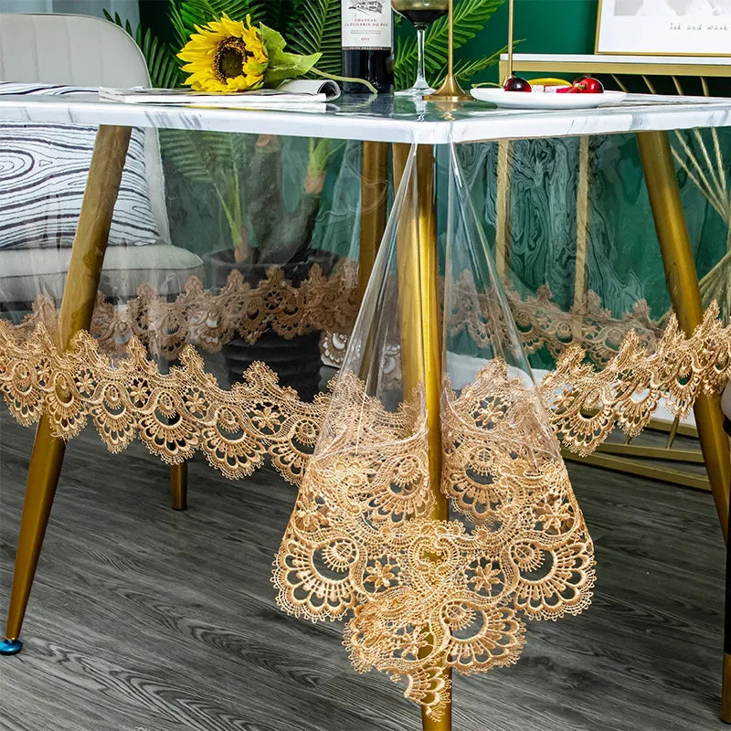 Gold lace embroidered PVC tablecloth draped over a glass table.