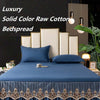 A luxurious navy blue solid color raw cotton bedspread and pillows with gold embroidery on a bed.