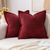 A deep red striped corduroy lumbar support pillow cushion resting on a light-colored sofa.