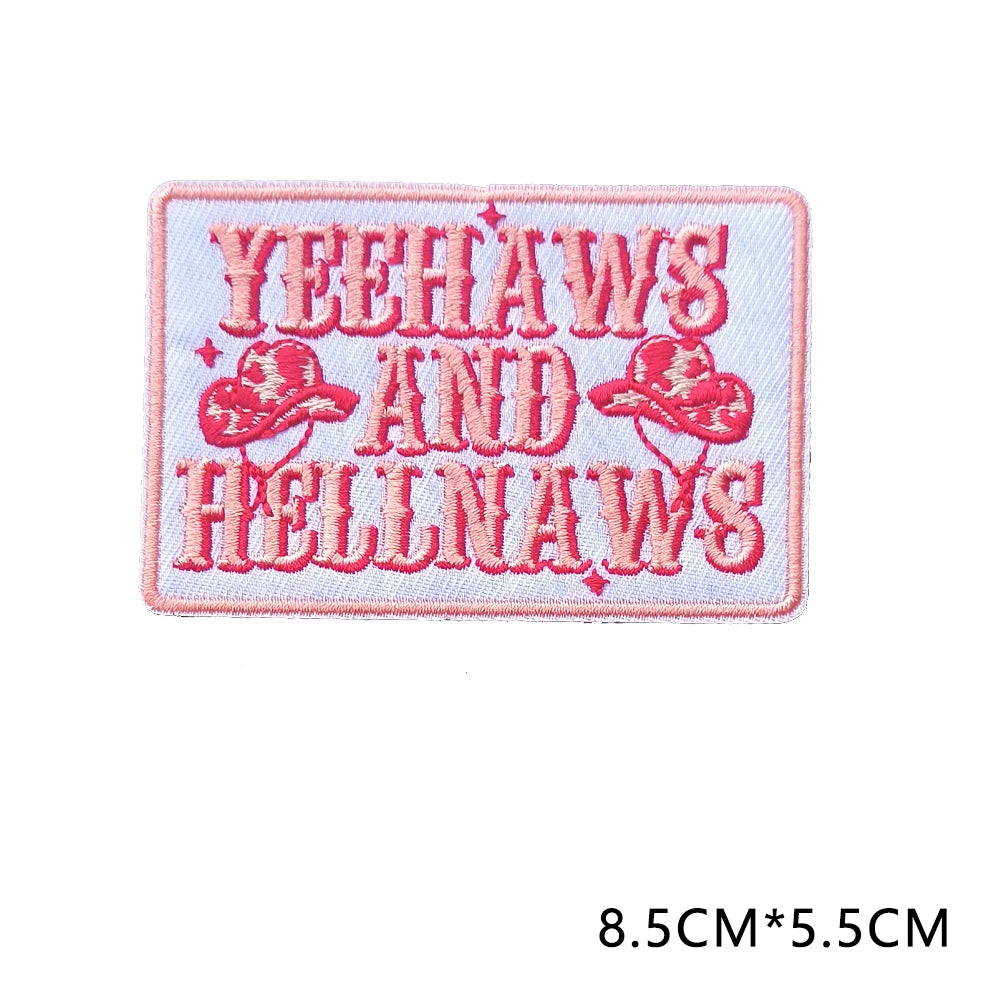 Pink embroidered letter patch with the text YEEHAWS AND HELLNAWS in red thread.