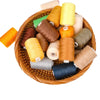 A collection of ten rolls of various colored polyester sewing thread arranged in a woven basket.
