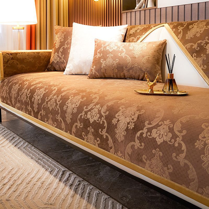 A luxurious bed featuring a brown patterned velvet cover, white pillows, and gold accents in a modern room.
