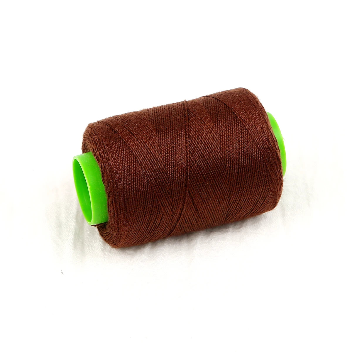 A roll of dark brown sewing thread with bright green tape visible on the ends.