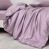 A smooth lavender luxury bamboo duvet cover set draped over a bed with a matching pillow.