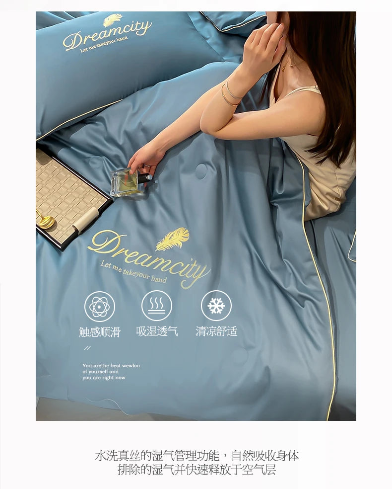 A close-up of a light blue ice silk fiber quilt with a gold trim, showing a hand touching the fabric.