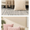 A collection of pink and beige textured plush pillows arranged on a light-colored sofa for home decor photography.