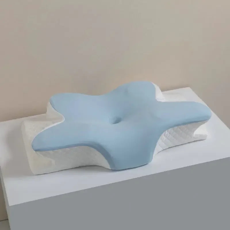 Light blue cooling memory foam pillow with neck support resting on a white surface.
