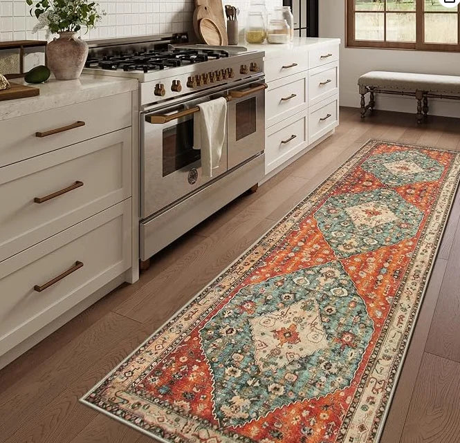 A long vintage trellis rug runner with geometric patterns in orange, blue, and cream laid on a wooden floor.