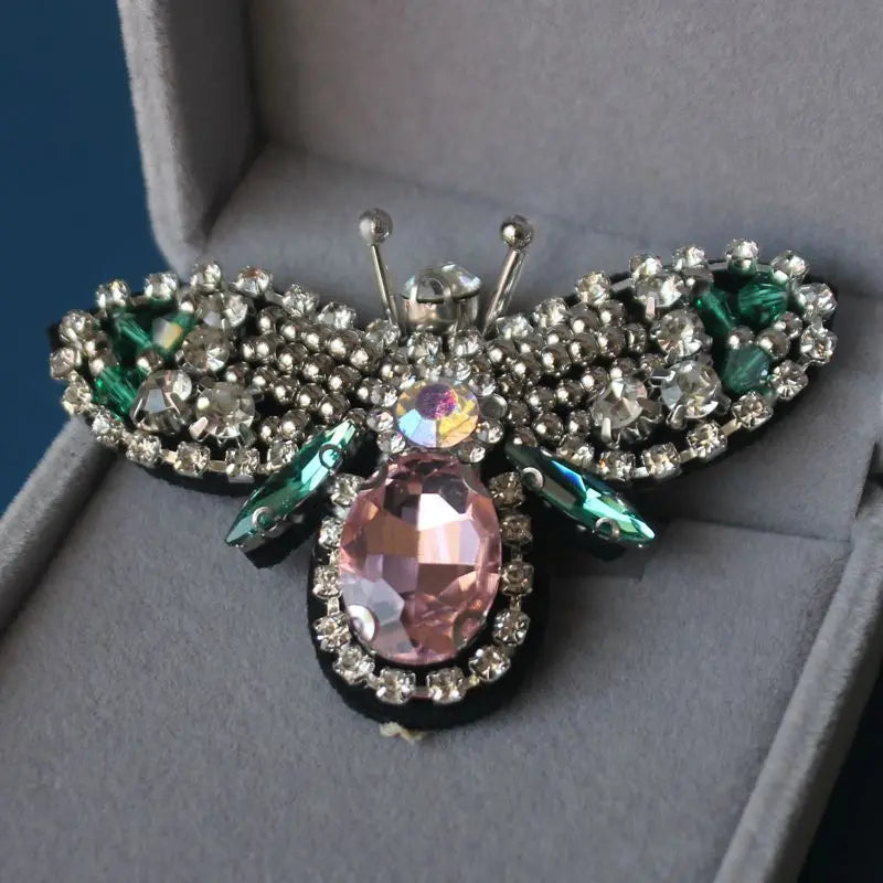 Handmade bee beaded sew-on patches with sparkling silver and pink accents displayed in a box.