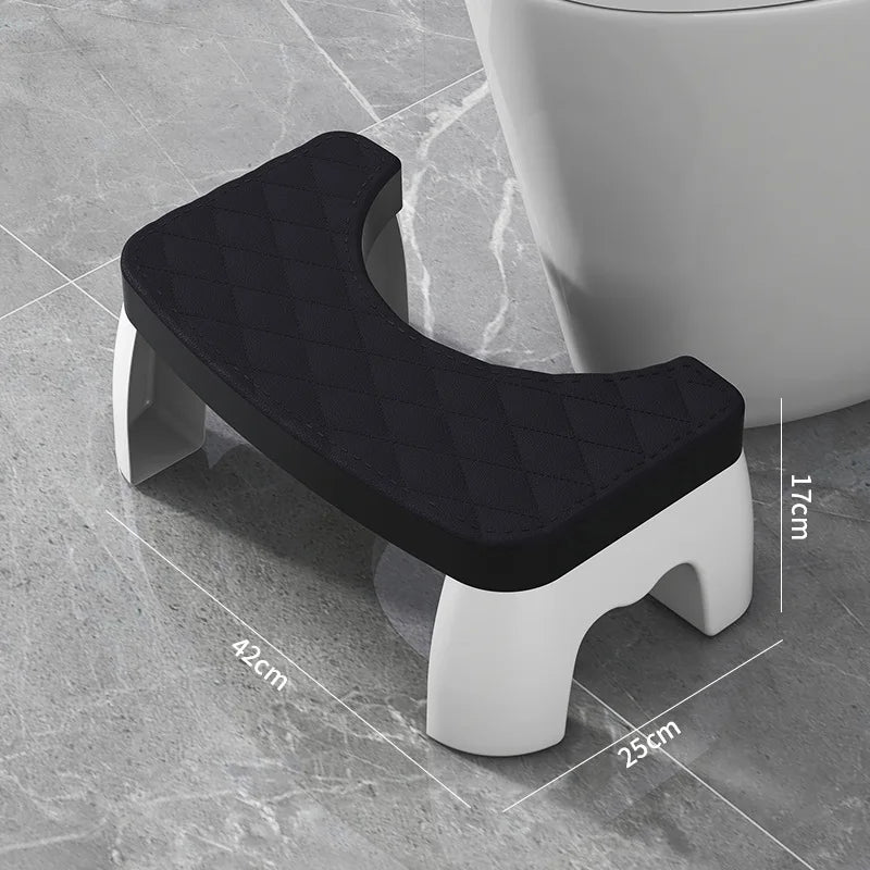 A black adjustable adult toilet squat stool with white legs shown on a gray floor.