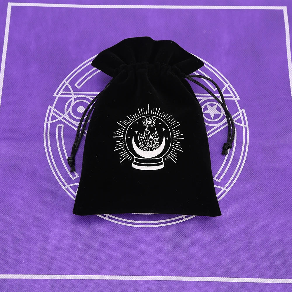 A black velvet tarot cards storage pouch with a white circular design featuring a sun symbol and crescent moon.