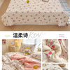 Pink floral quilt with yellow cartoon bears and roses displayed on a bed.