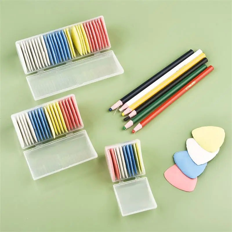 A collection of colorful erasable fabric chalk markers in various shades and sizes arranged on a light green surface.
