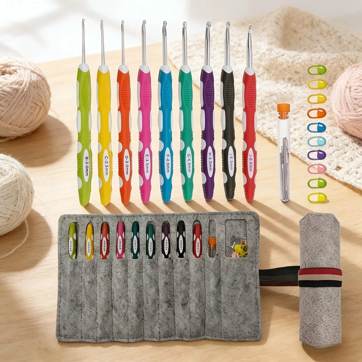A collection of colorful ergonomic felt crochet hooks in various sizes arranged on a wooden surface.