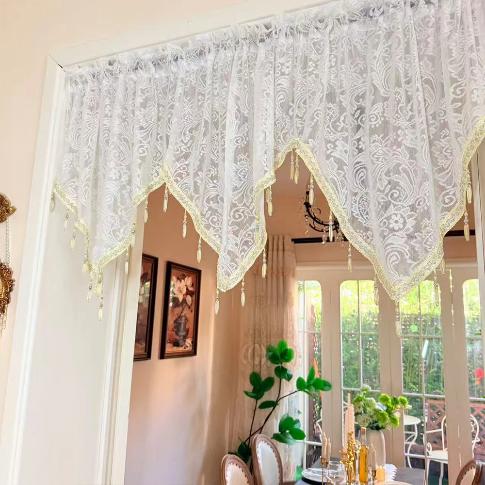 Elegant black lace curtain valance with sheer white overlay and fringe hanging over a doorway.