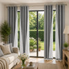 Set of four grey and white linen textured blackout curtains hanging in a modern living room