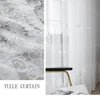 White embroidered floral tulle window curtain with sheer fabric and a gold accent table.