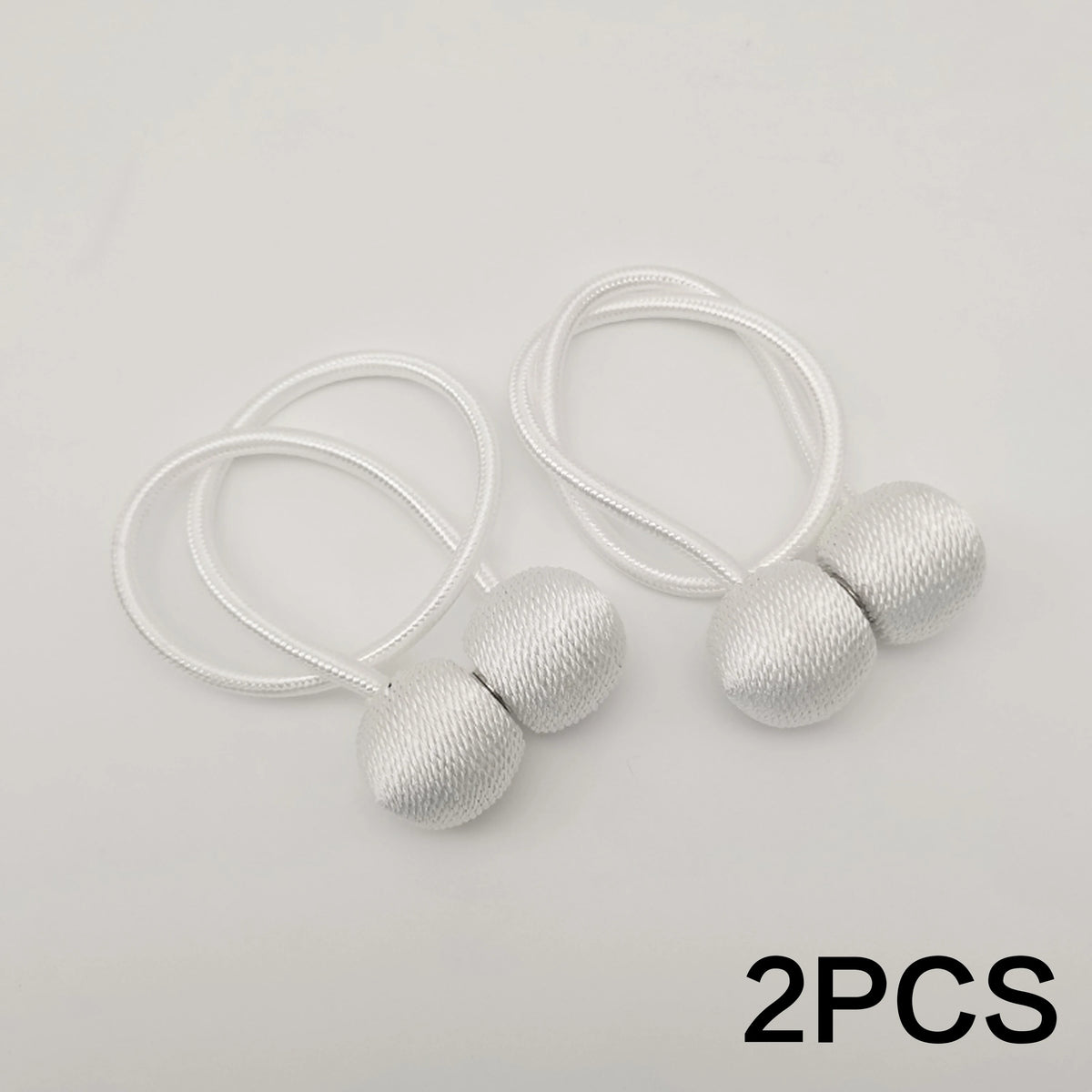 Two silver-colored magnetic ball curtain tiebacks with white cord.