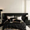 A luxurious black and gold bedding set featuring a tufted headboard and white linens in a modern bedroom.