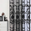 Black sheer curtain featuring intricate lace embroidery with pearl accents.